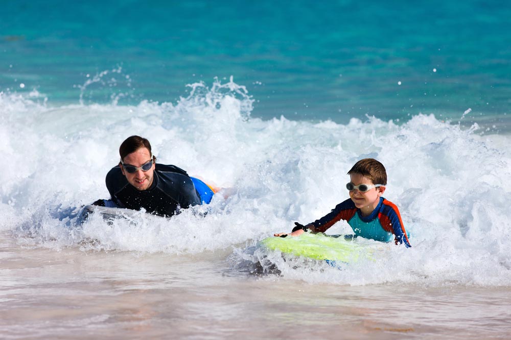 Father and son surfing on boogie boards